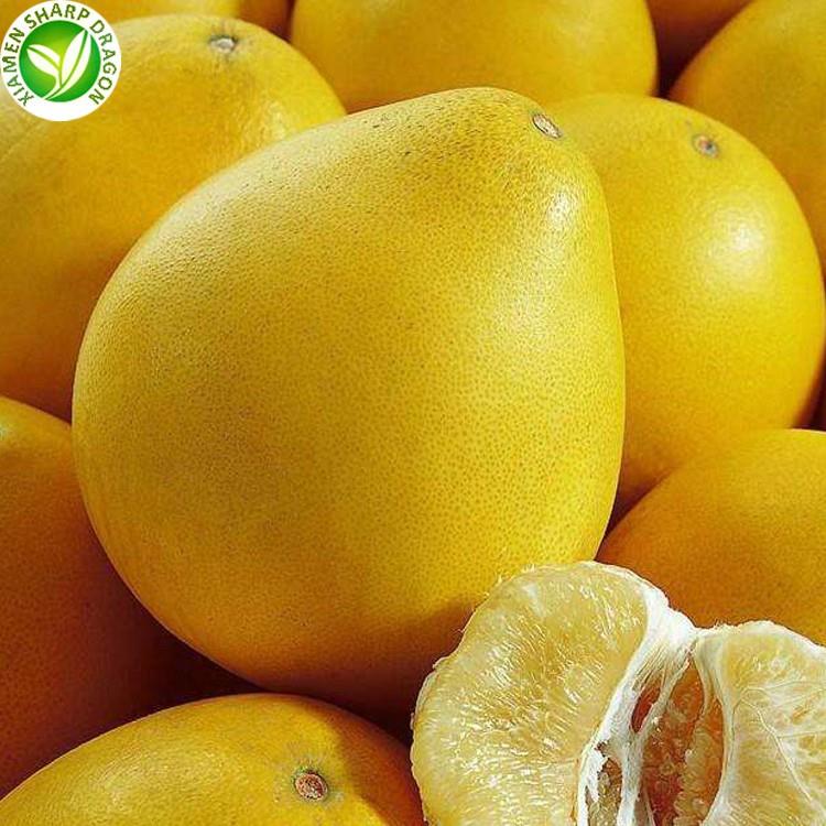Whole yellow pomelos with a partly peeled segment in front