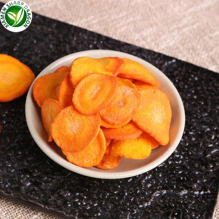 Orange carrot crisps in a shallow white bowl