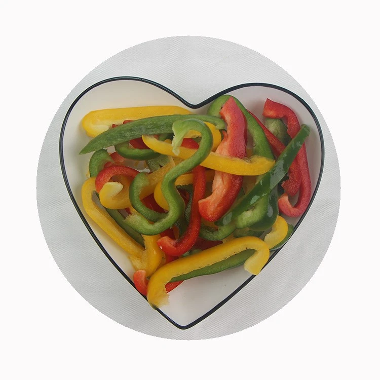 Mixed bell pepper strips ready for cooking Red yellow and green bell pepper strips in a serving bowl