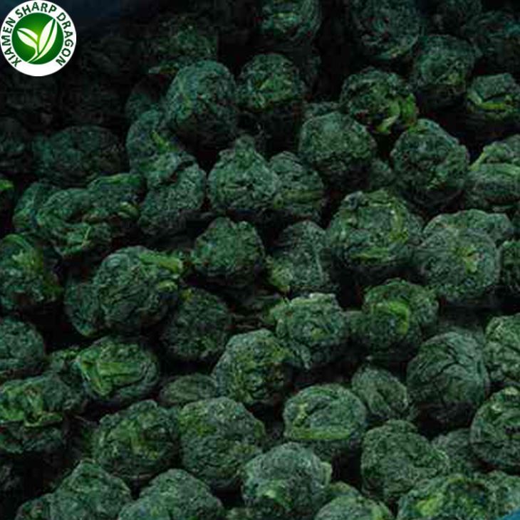 Close view of many dark green frozen spinach balls